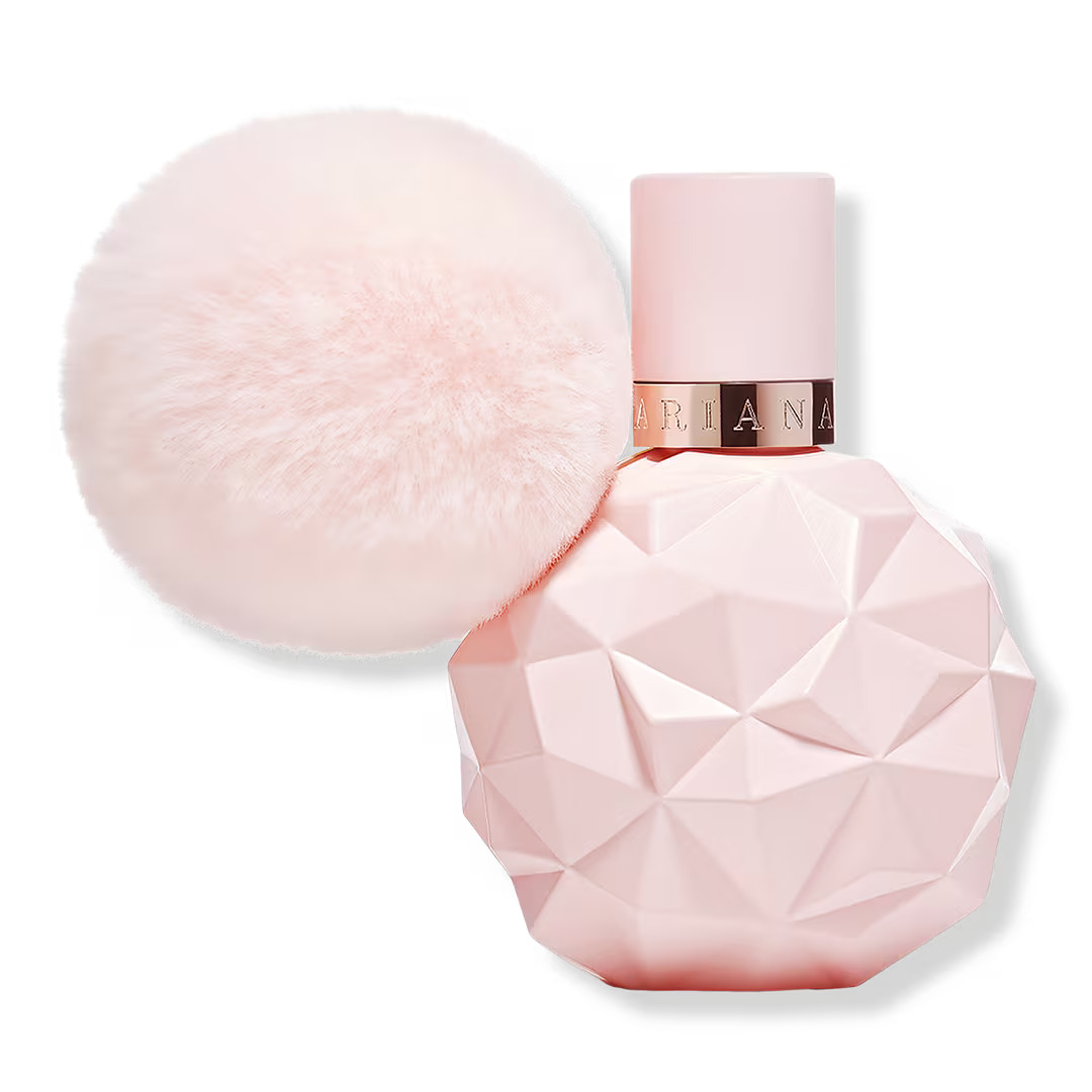 The Sweet Like Candy perfume which is round light pink bottle with a geometric design. The bottle has a pink fluffy ball attached to it.