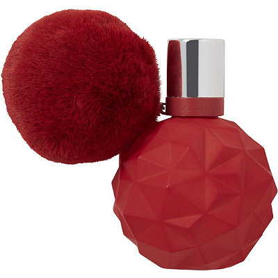 The Limited Edition Sweet Like Candy perfume which is in a red round bottle with a geometric design. The bottle also has a red fluffy ball attached to it.