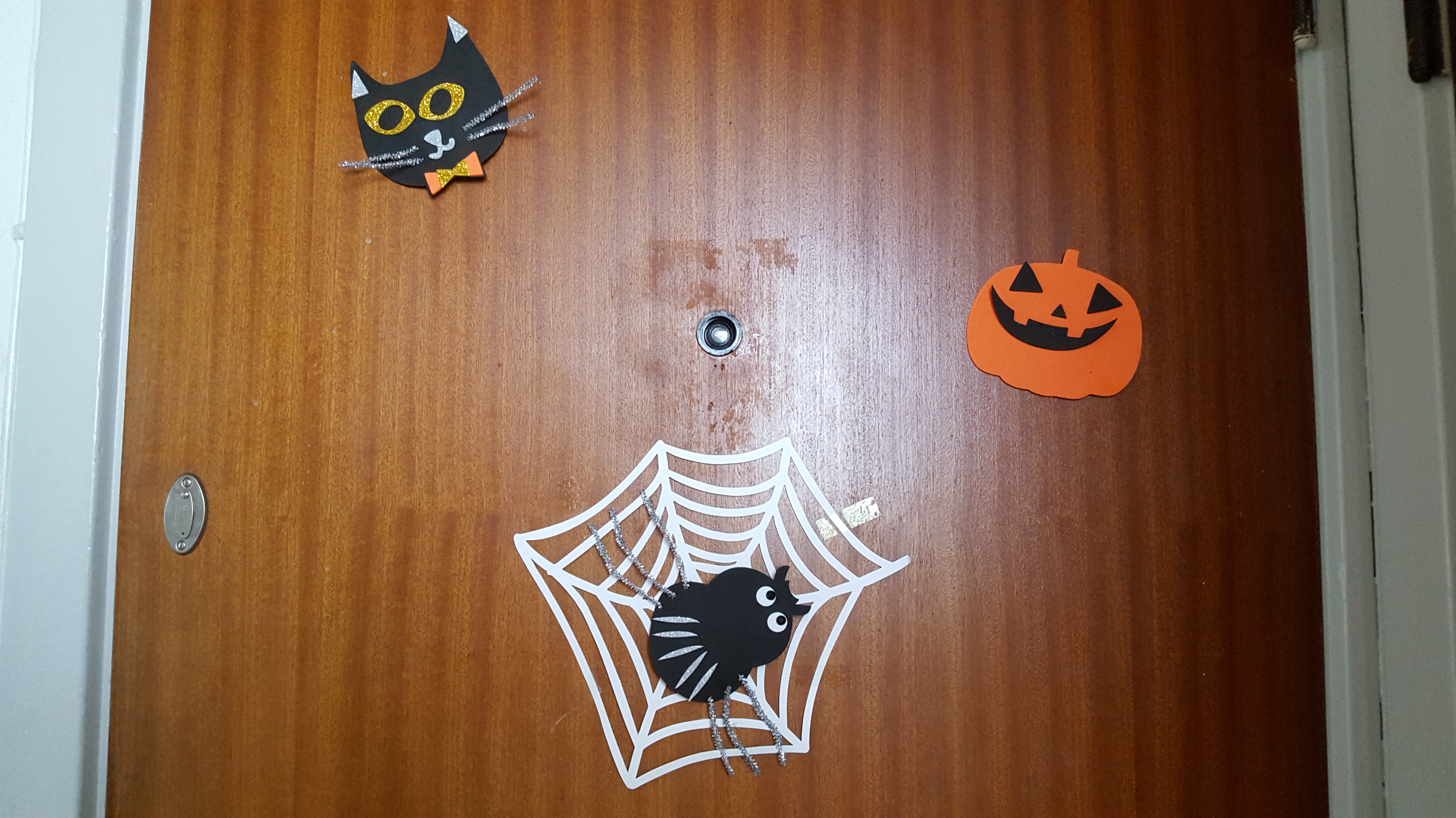 Crafted foam cat, pumpkin, and spider on the door