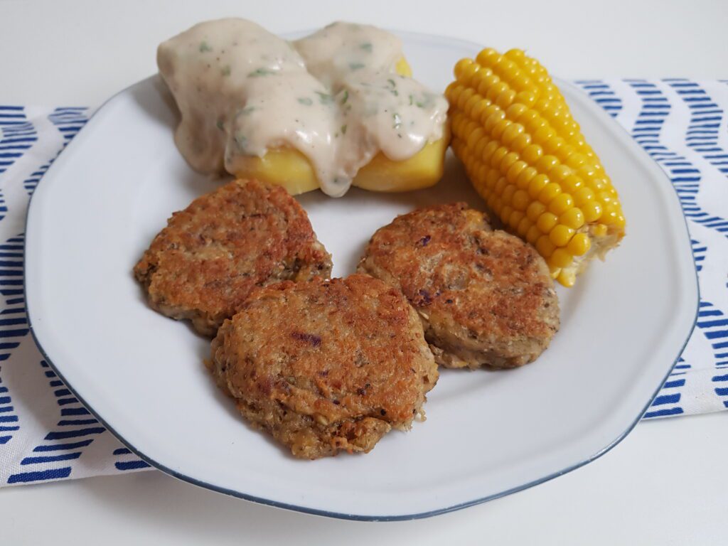 The finished vegan frikadeller with potatoes, parsley sauce, and corn on the cob