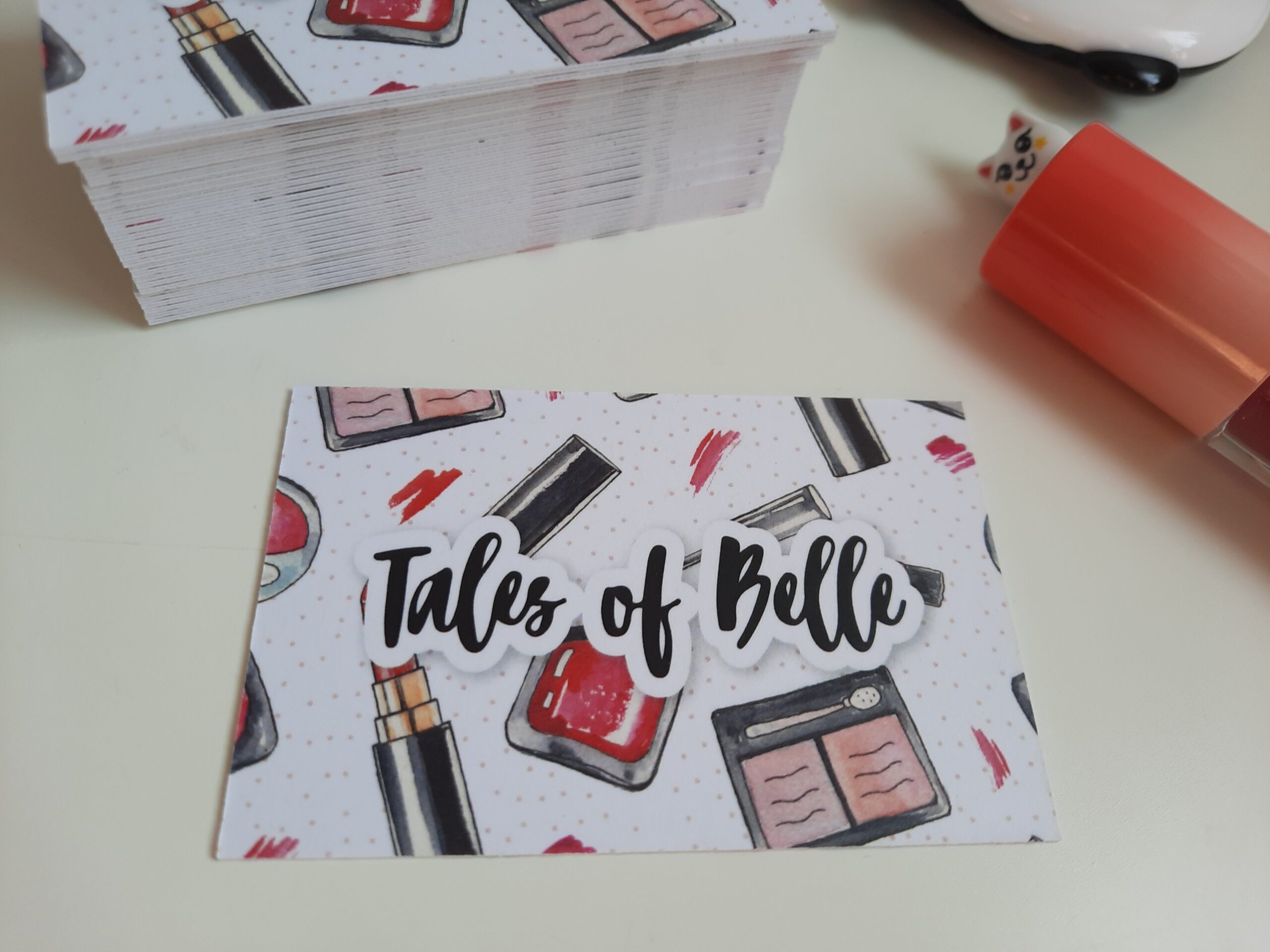 The recycled paper business cards I received from Aura Print. The front side of the business card is showing, which features my blog name Tales of Belle and cartoon images of makeup products.