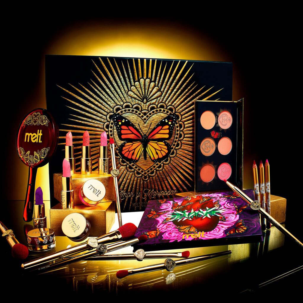 The Melt Cosmetics Amor y Mariposas collection including an eyeshadow palette, blush palette, lipsticks, lip pencils, gel liners, and pigment paint. 
