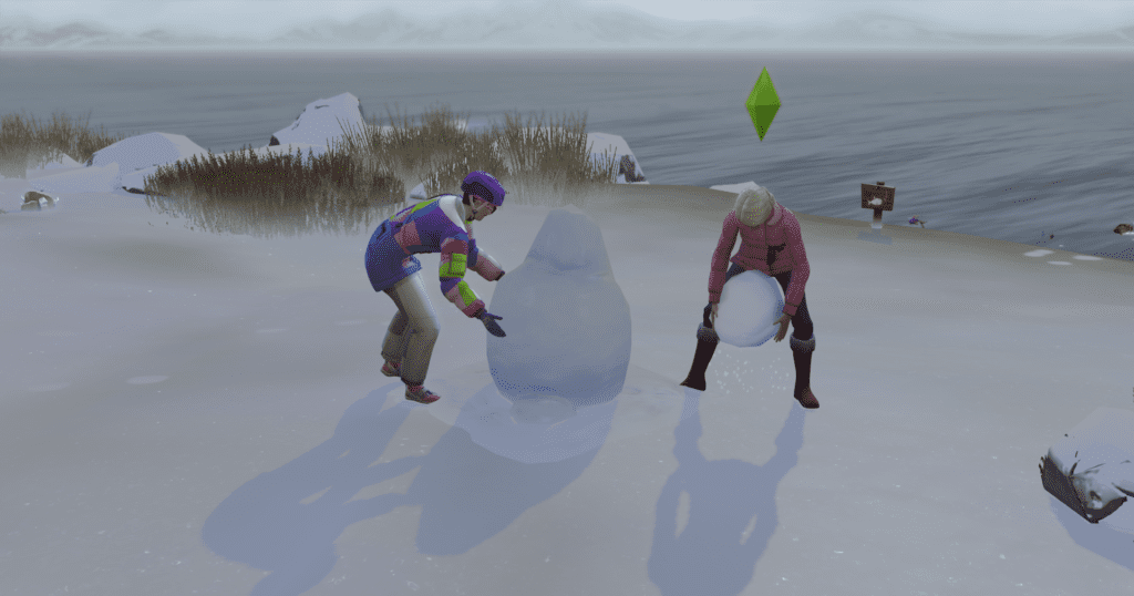 Two of my sims building a snowman during winter