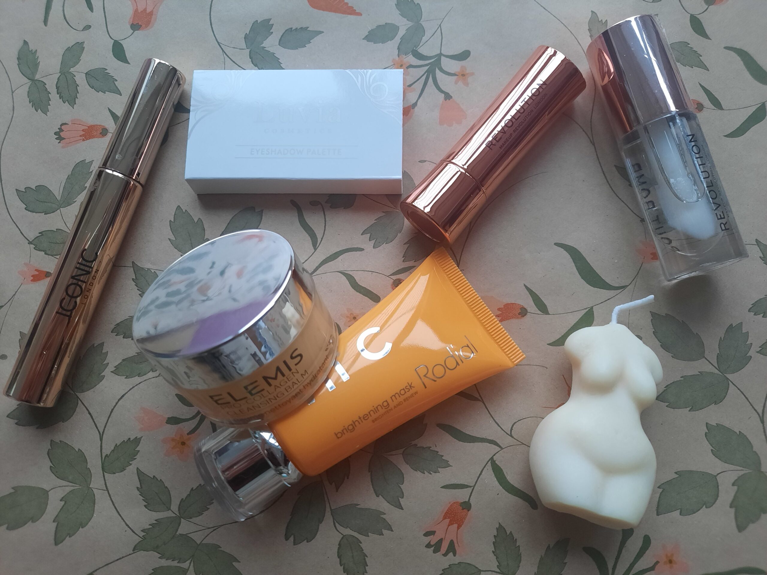 Some of the makeup and skincare items from the LookFantastic Beauty Advent Calendar along with the Demi candle from the calendar