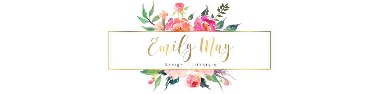 The logo for Emily May. Emily May is written in a gold, cursive font and underneath is Design and Lifestyle in a plain black font. In the background is a bouquet of illustrated pink flowers.