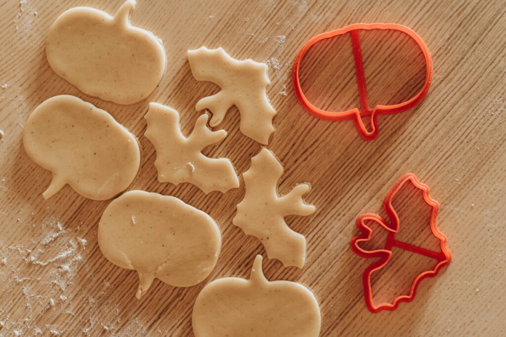 Cookie dough that is cut out into the shapes of pumpkins and bats.