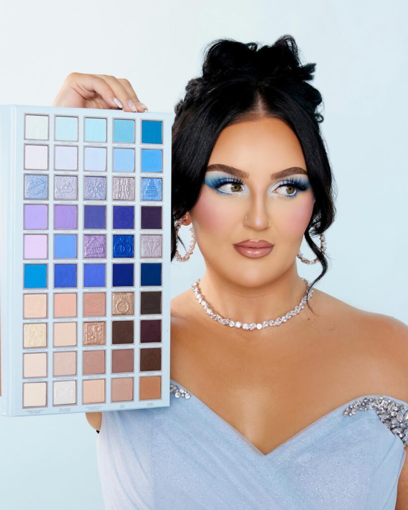 Mikayla holding the P. Louise To Have & To Hold In Case You Get Cold Palette, which is a huge 50-shade palette with mostly blue and neutral shades. 