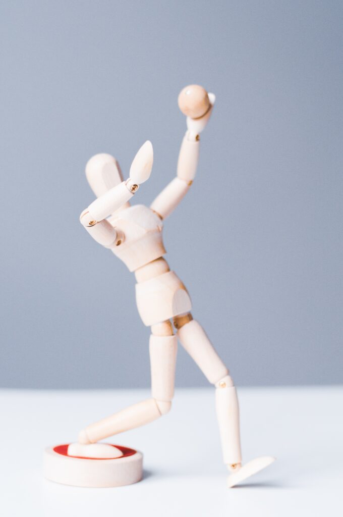 A wooden mannequin figure that is posed