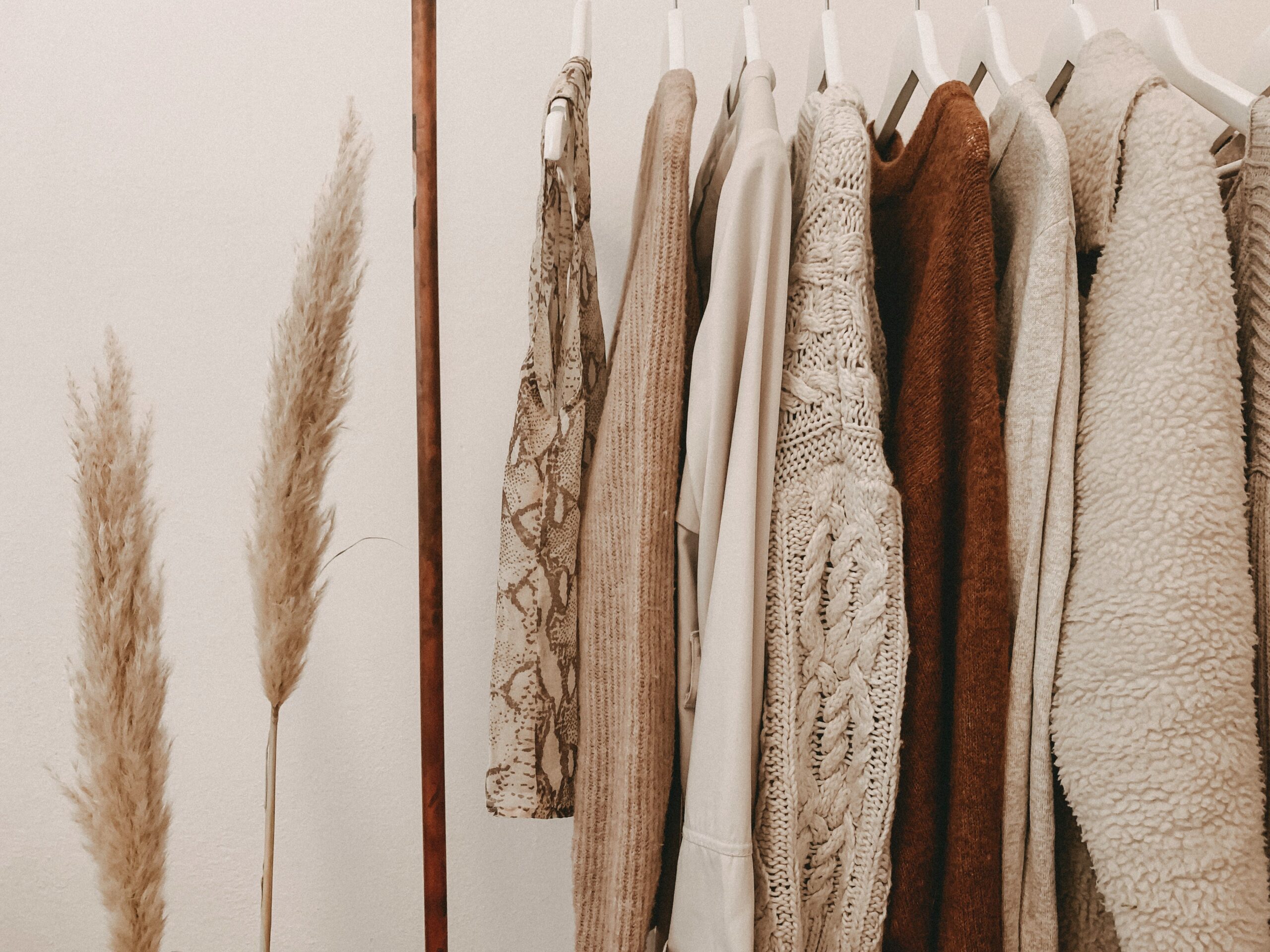 A clothing rack with neutral colored clothing