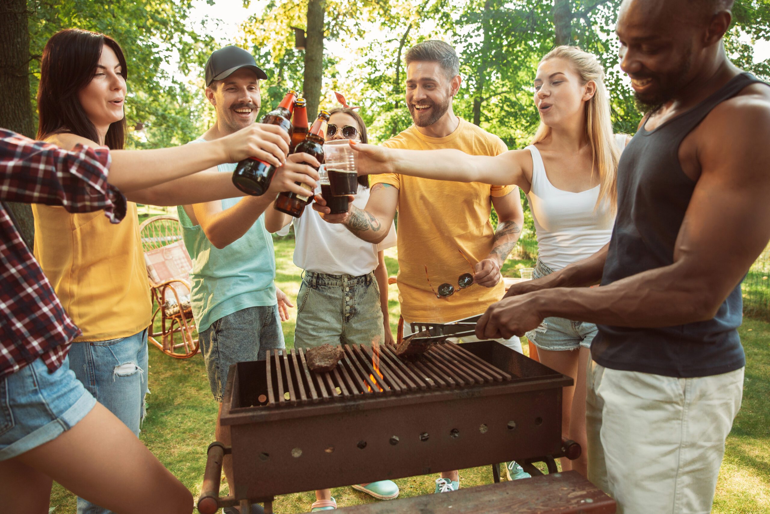 A ground of friends having drinks at a barbecue party. 