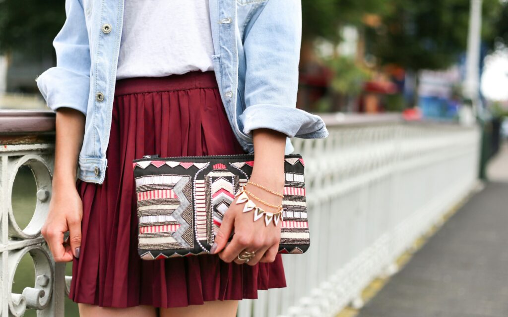 A black, white, and pink patterned clutch handbag.