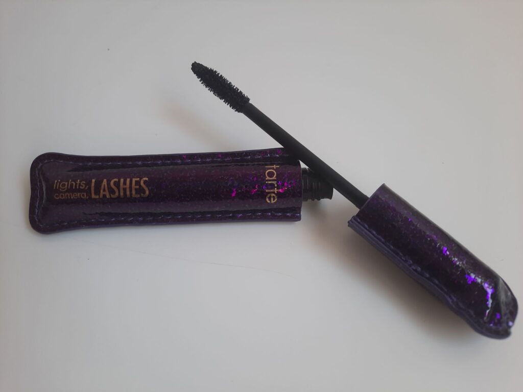The full size of the Tarte Lights, Camera, Lashes Mascara which is a purple textured tube with gold lettering 