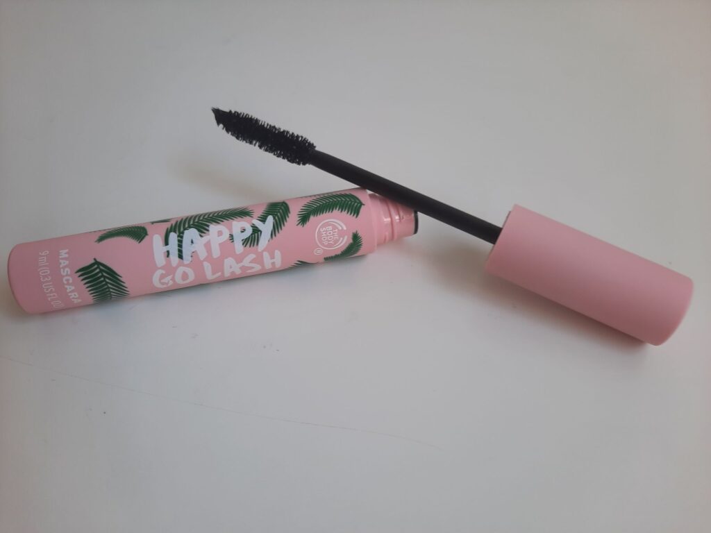 The full size of The Body Shop Happy Go Lash Mascara which is a pink tube with green leaves on the side