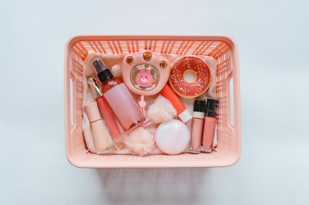 A pink basket filled with makeup and beauty products.