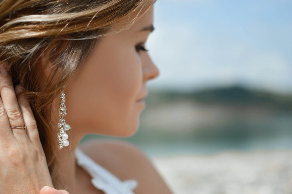 A woman wearing chandelier style diamond earrings
