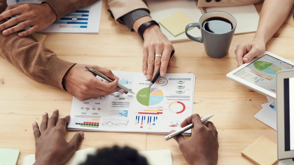 Individuals gathered around a table and discussing a business plan