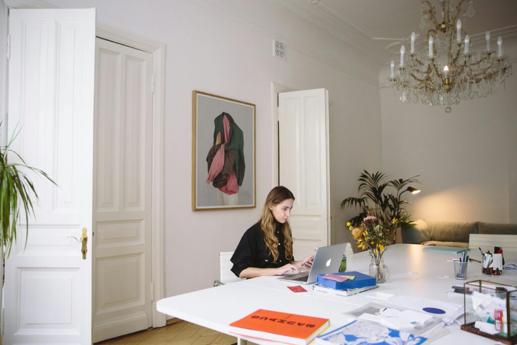 A woman sitting at a table and working on a laptop
