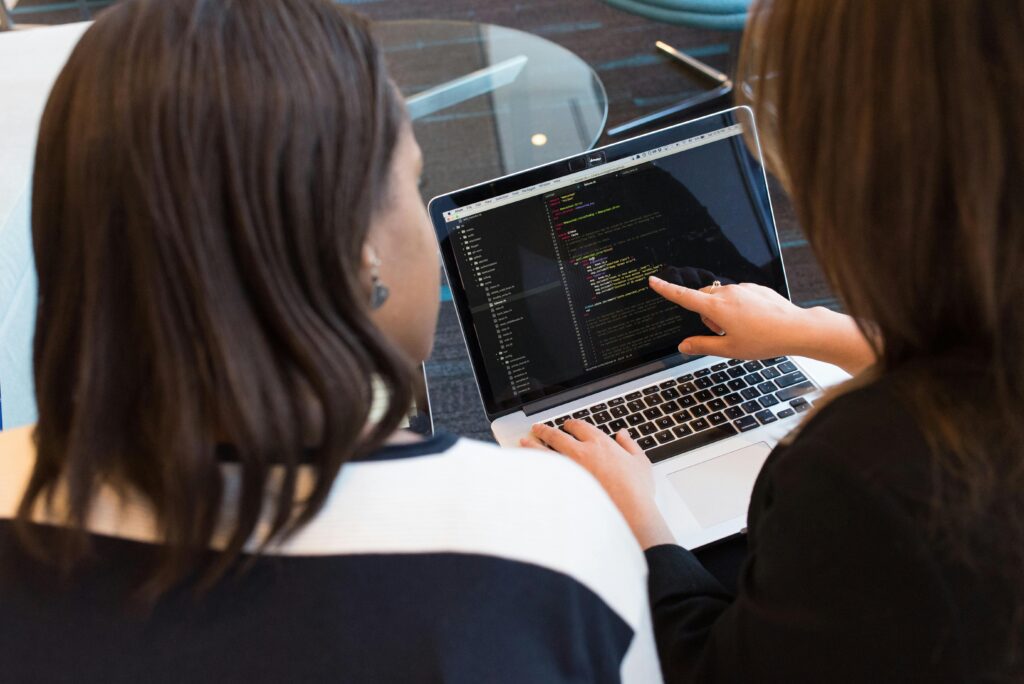 A woman working on coding on her laptop
