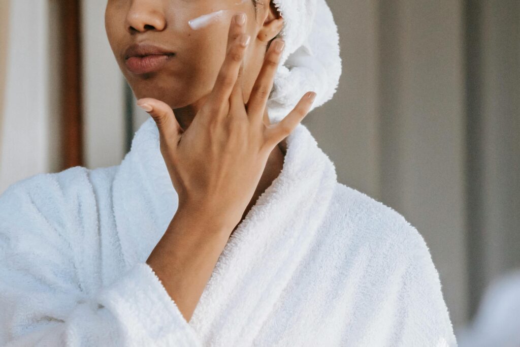 A woman applying moisturizer to her skin