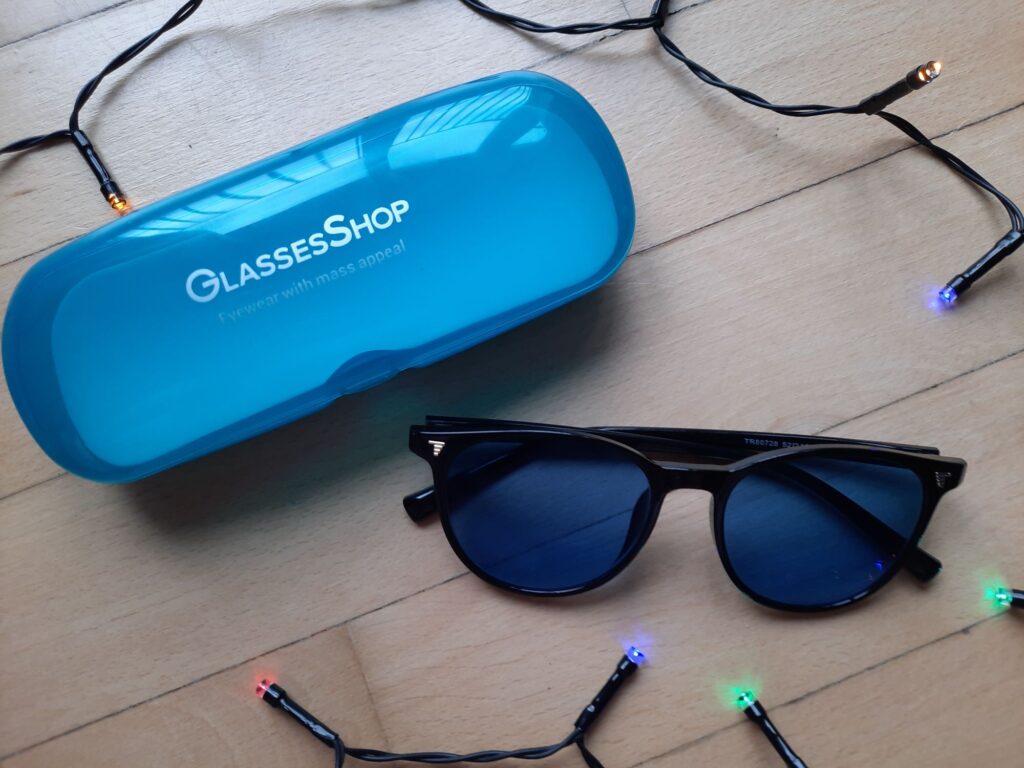 The Chamomile Round Black Sunglasses from GlassesShop which are black round frame sunglasses with a blue tint