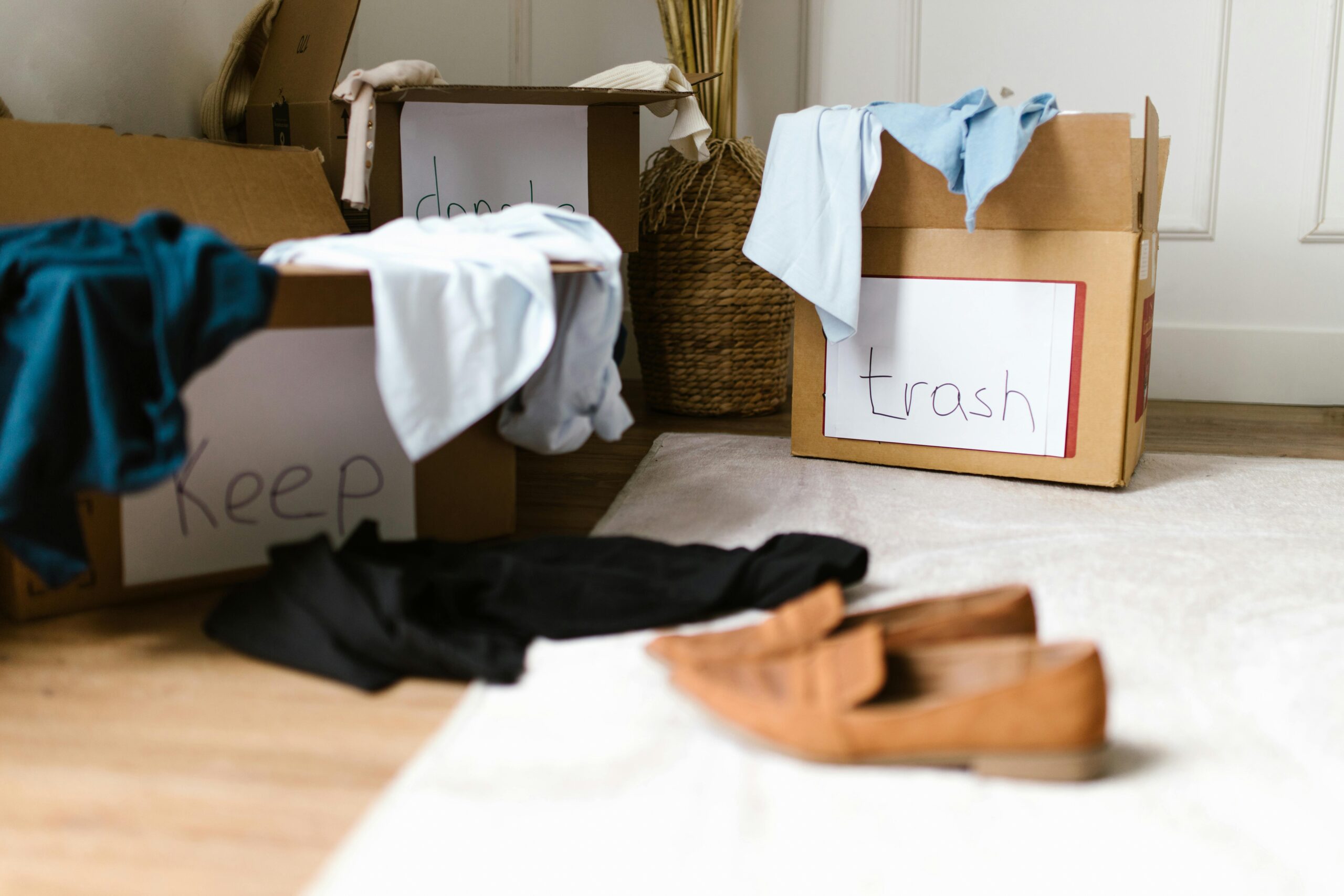 Cardboard boxes with keep, donate, and trash labels on the sides