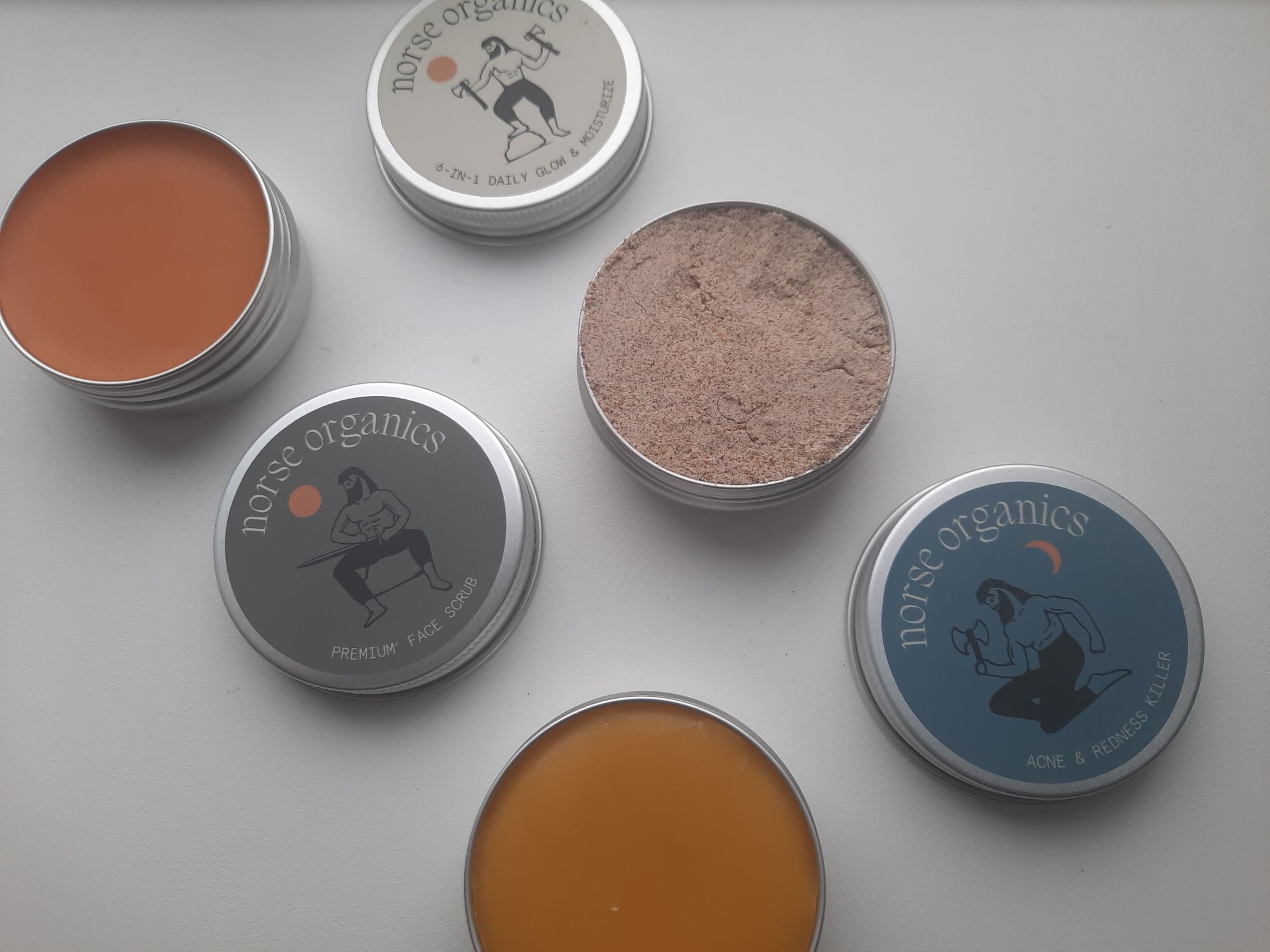 The 6-in-1 Daily Glow & Moisturize, Premium+ Face Scrub, and the Acne & Redness Killer opened to show the balms and scrub