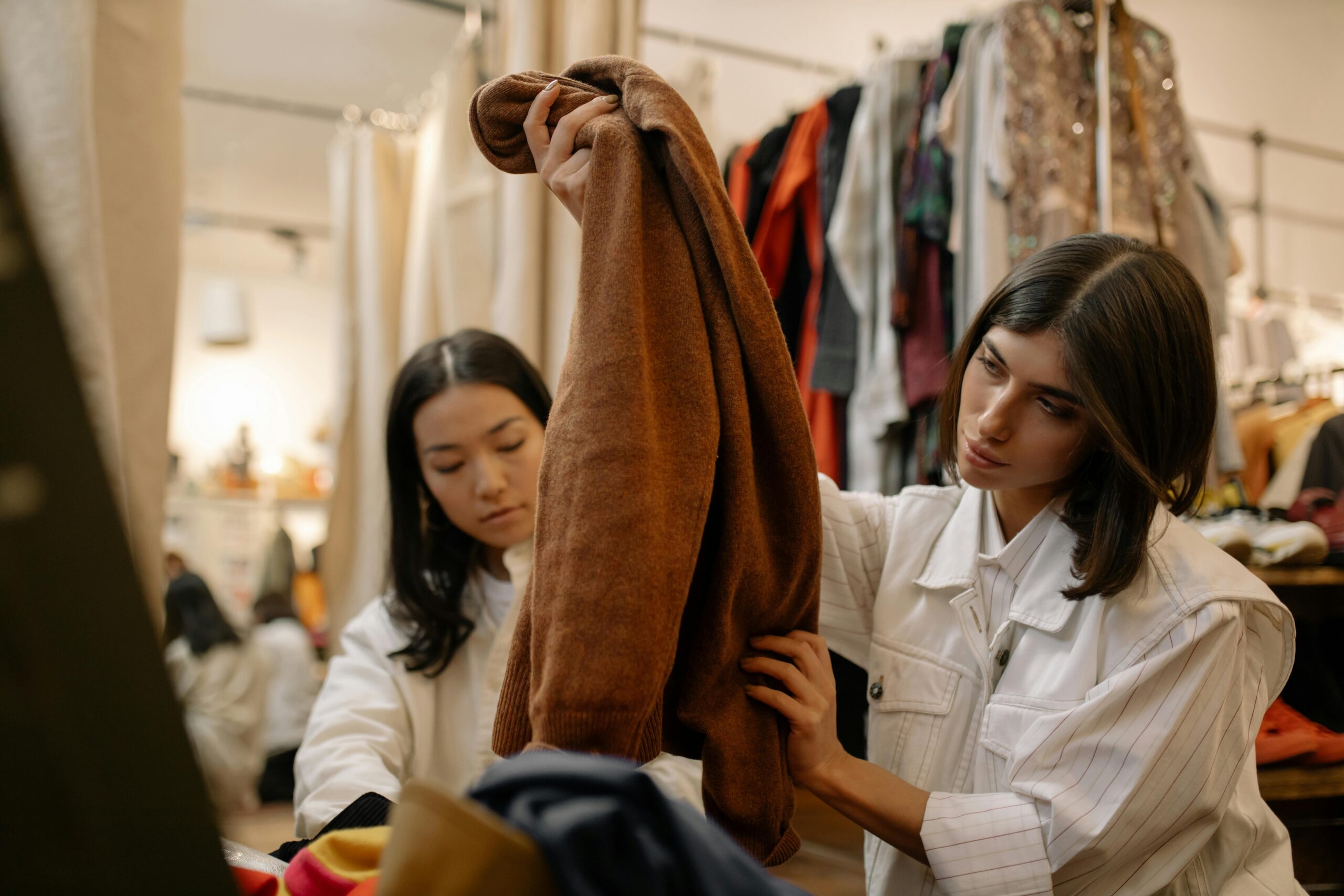 Two women looking at clothes in a thrift store