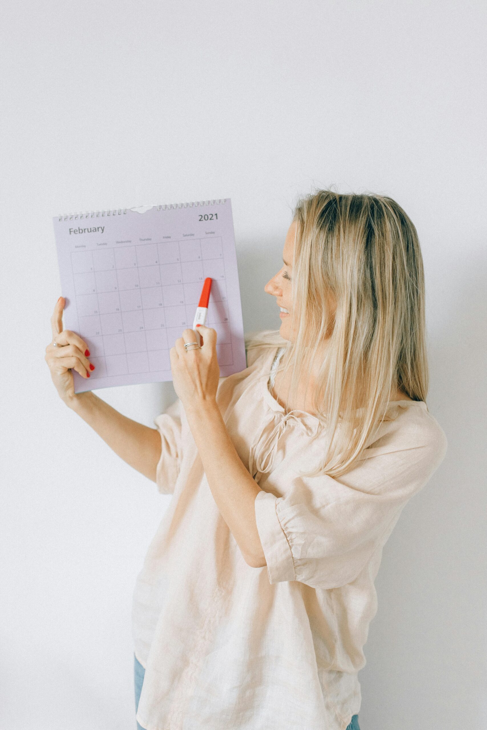 A woman with blond hair holding a calendar