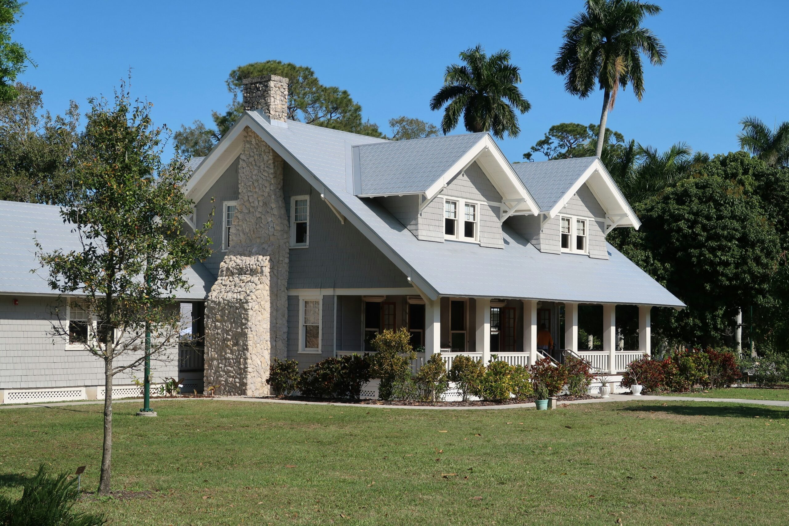 A brown and white concrete home with a green lawn