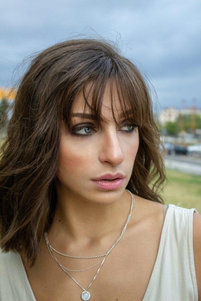 A portrait of a woman with brown hair and bangs