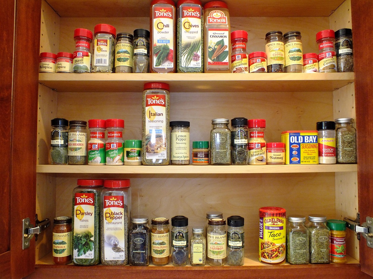 A cabinet filled with spices that is organized