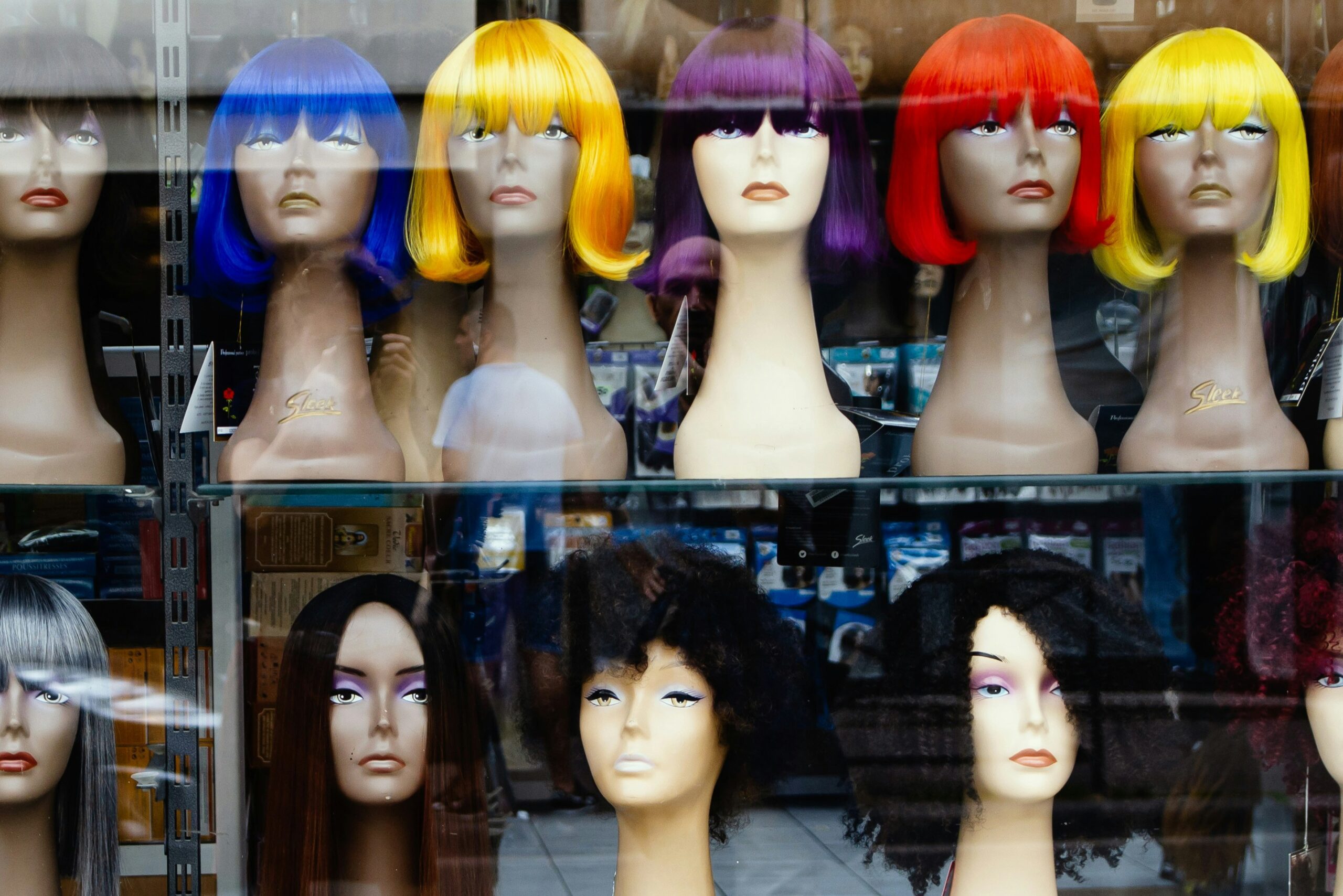 A selection of colorful and natural wigs for display on mannequin heads