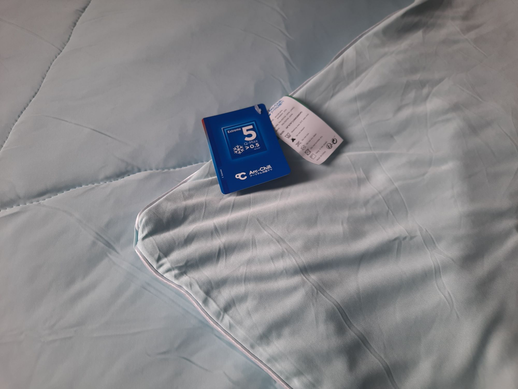The blue Elegear Cooling Comforter that shows both the cooling side and the soft side.