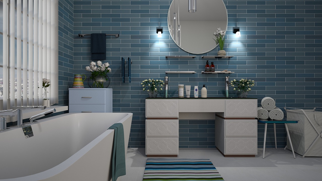 A bathroom with blue tiles and a white sink and tub.