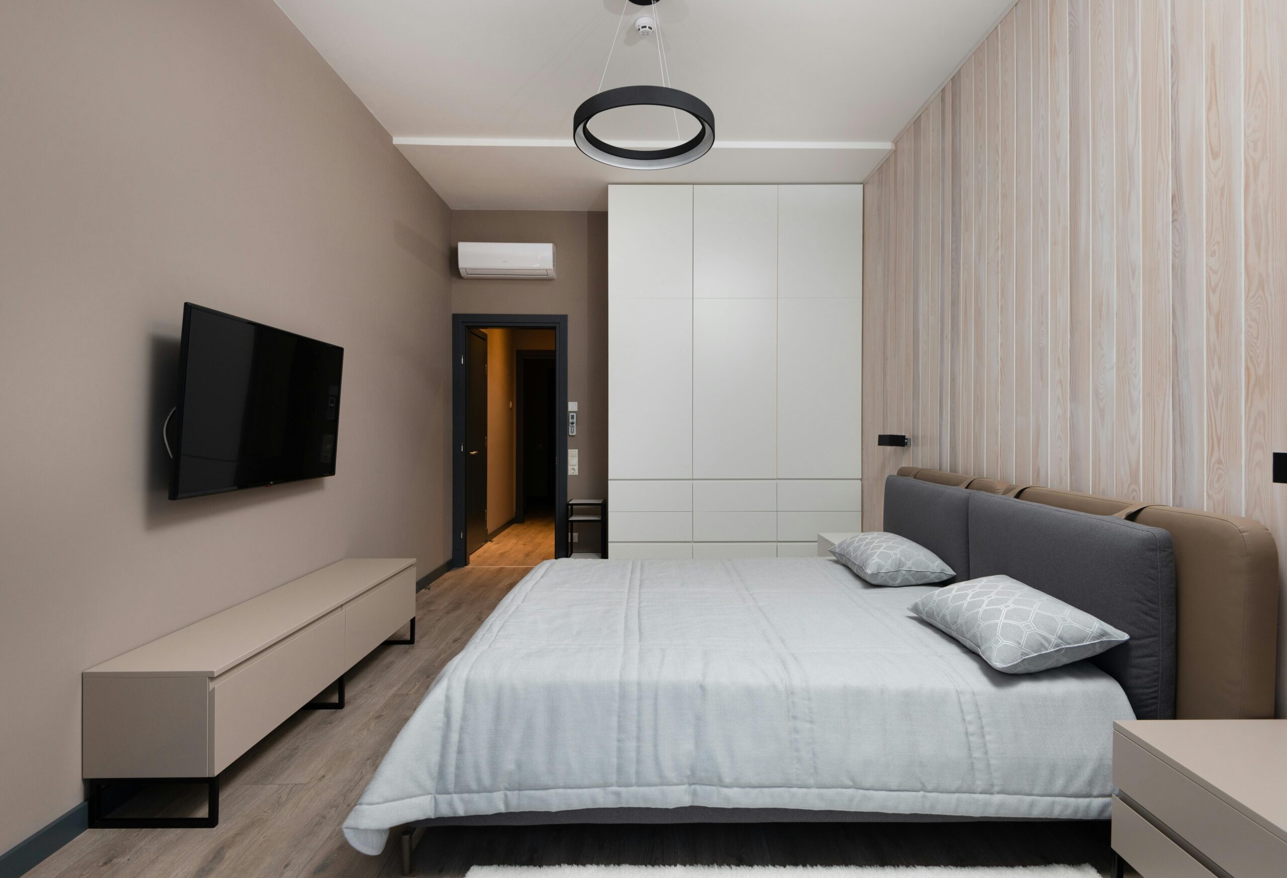 A modern bedroom with minimalist furniture and wooden parquet
