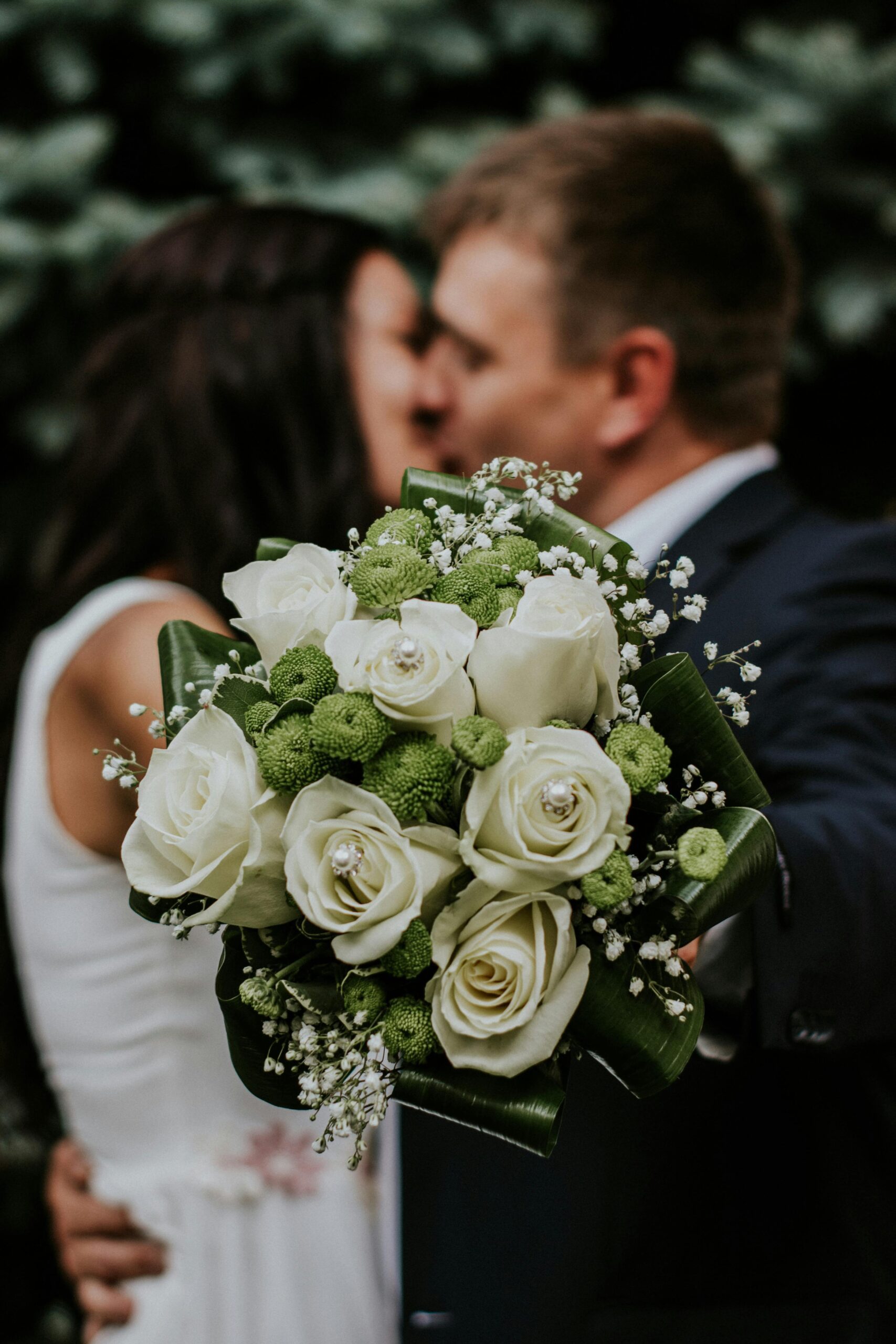 A man and woman kissing at a wedding
