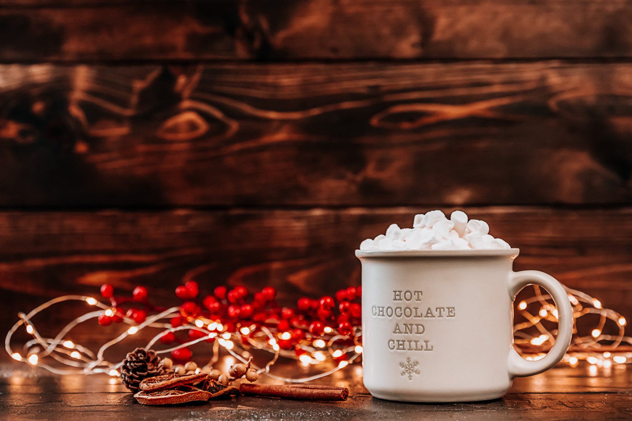 A mug topped with marshmallows with "hot chocolate and chill" written on the side