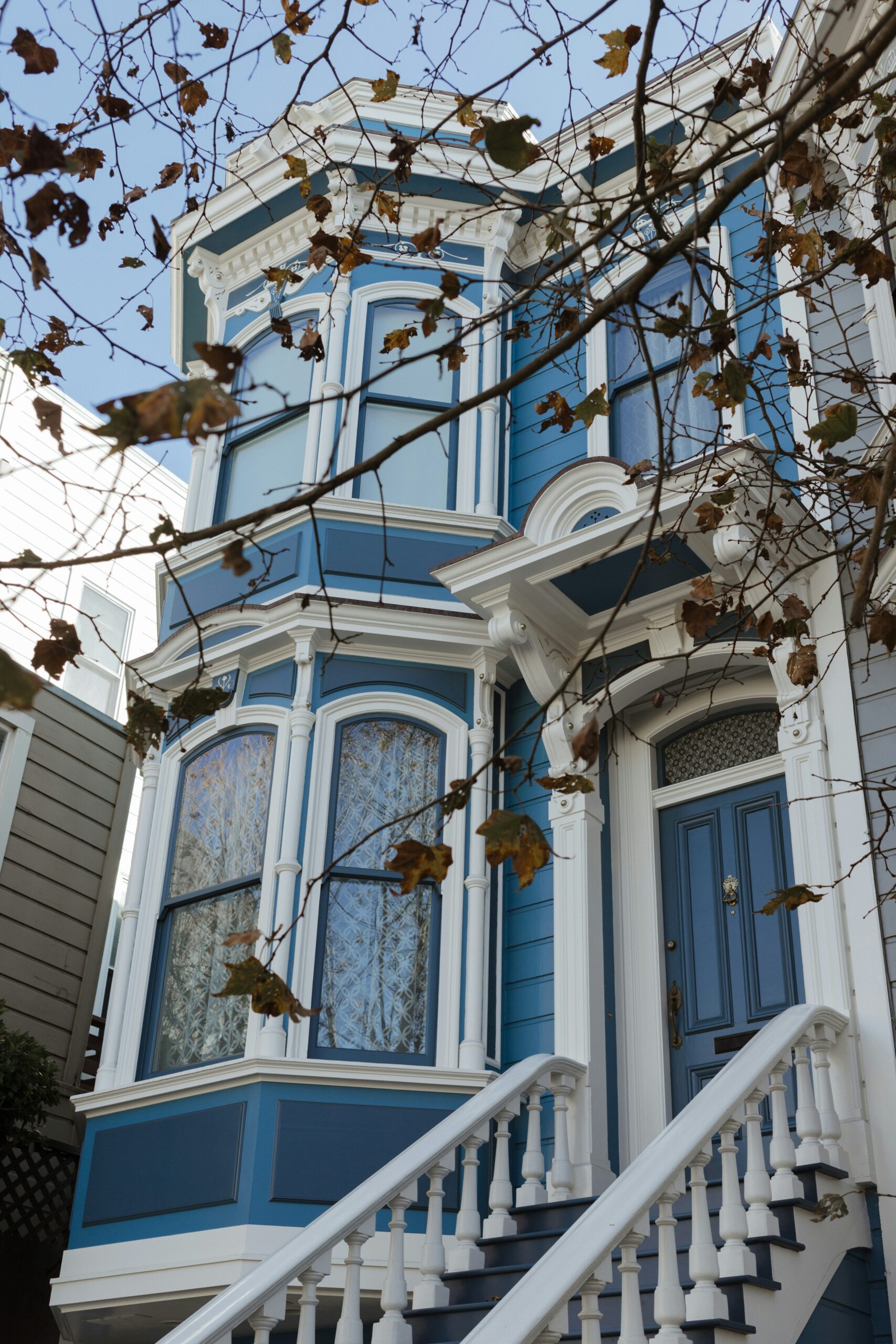 The exterior of a blue Victorian home with white trim