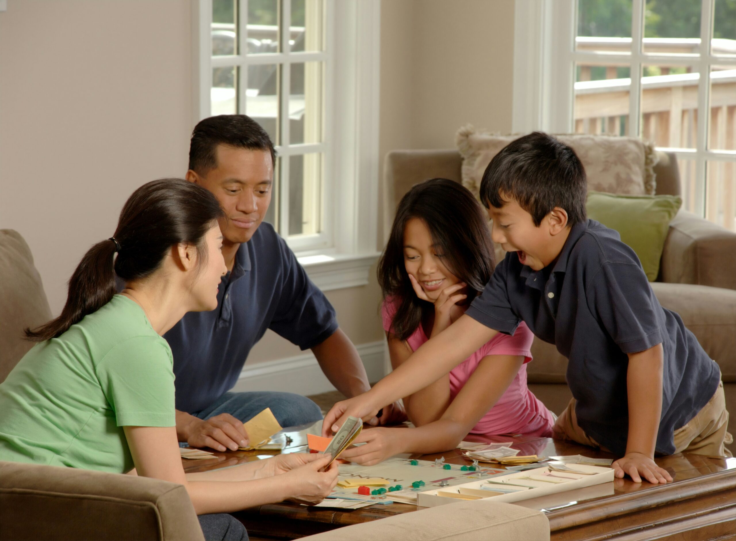 A family of four playing Monopoly together