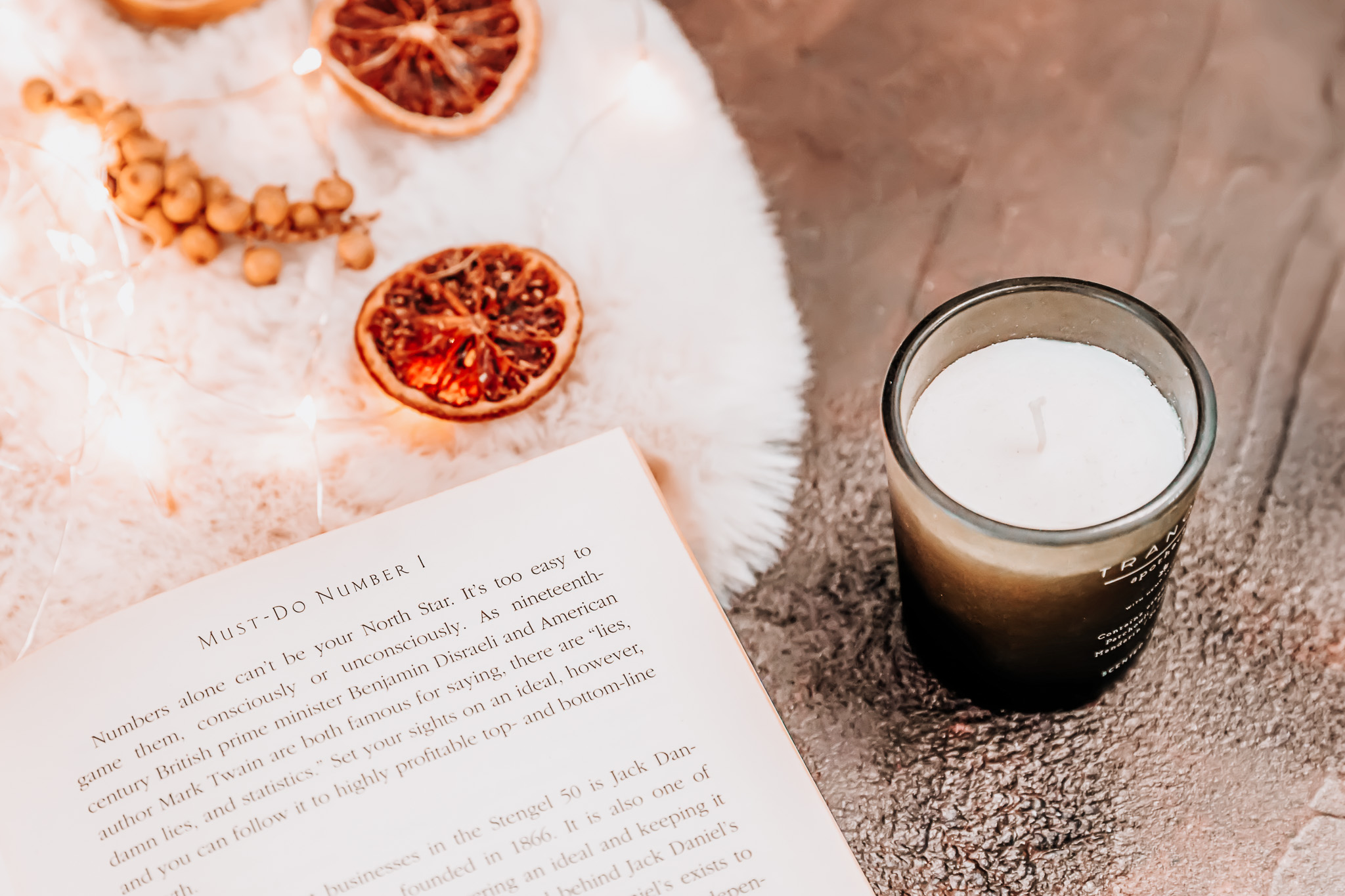 An opened book next to a candle