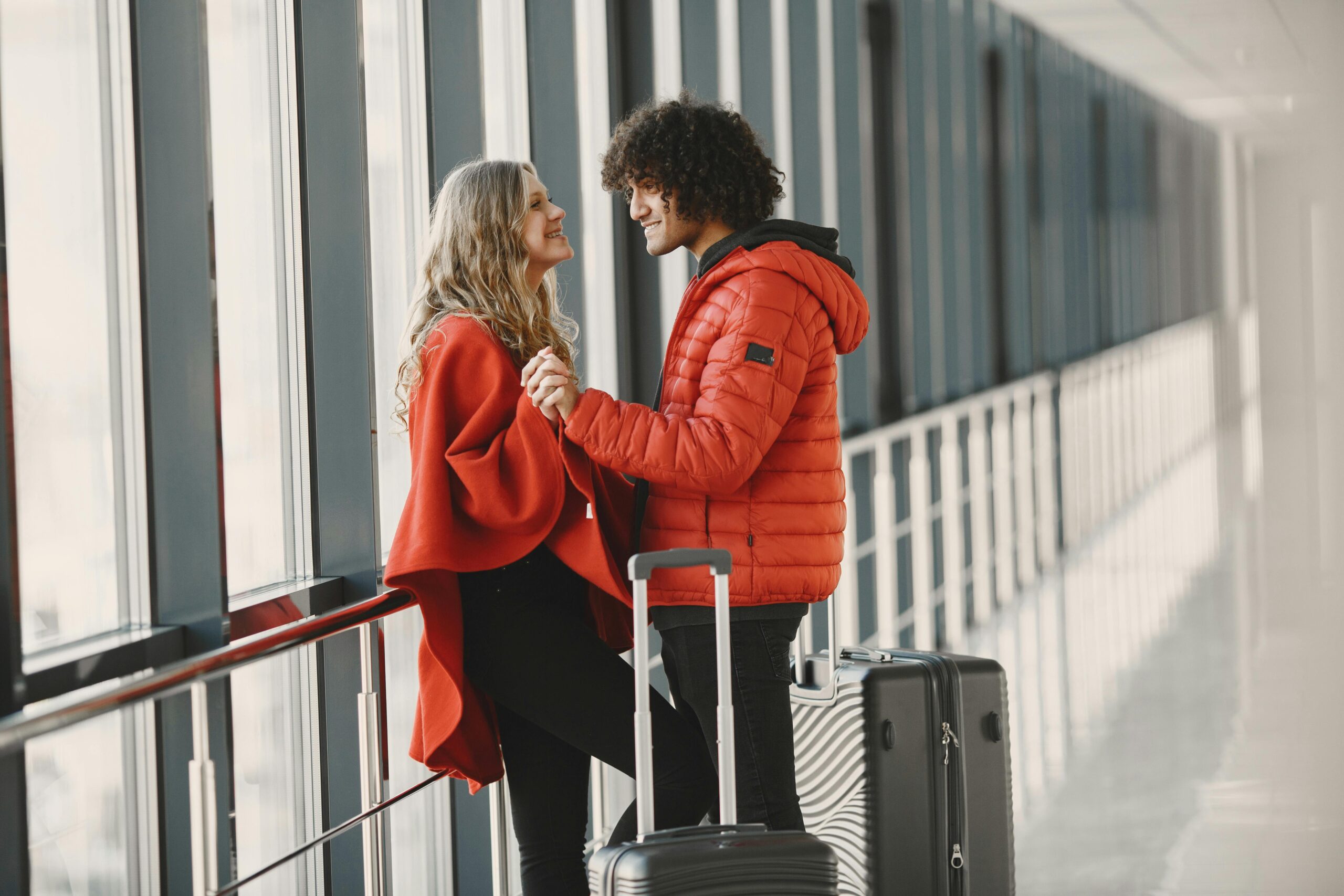 A couple holding hands and smiling at the airport