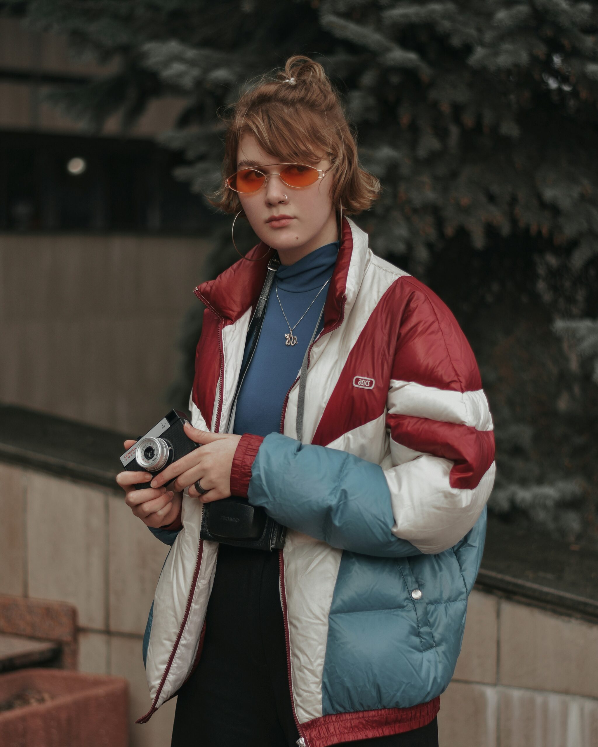 A woman wearing a 90s-inspired oversized jacket with a fitted top and black trousers