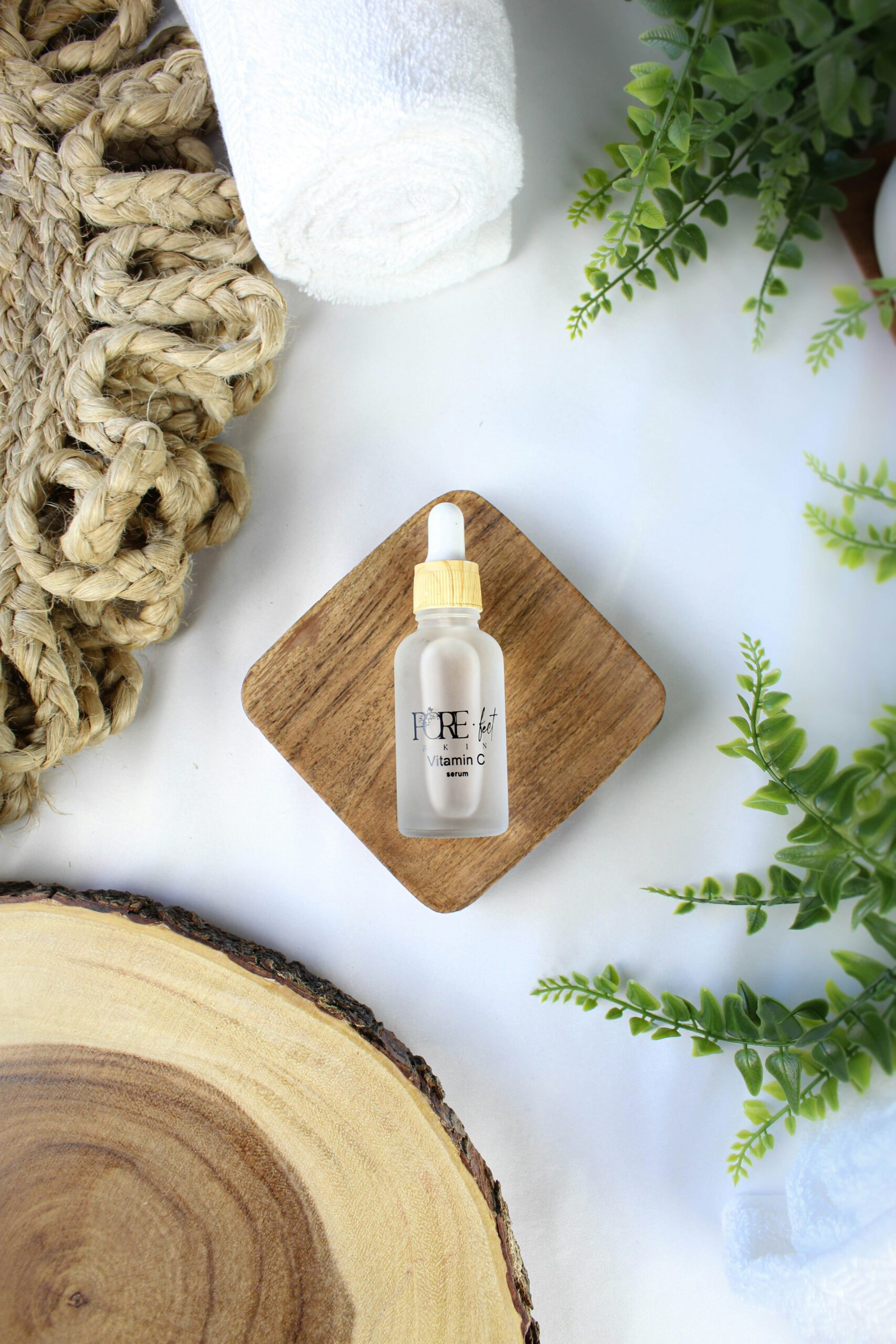 A vitamin c serum on a wooden coaster