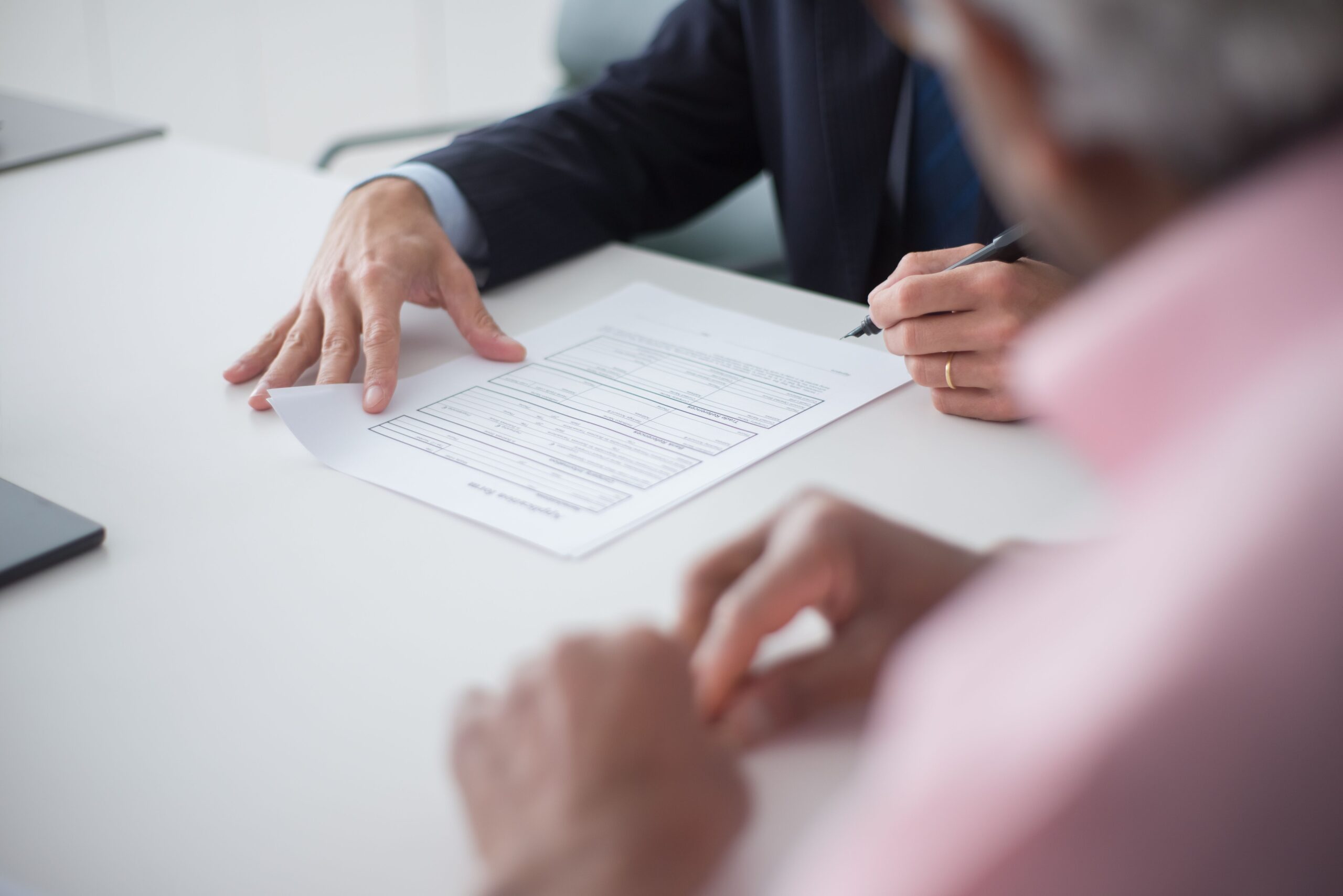 A close-up of a client meeting with a professional and reviewing a legal document