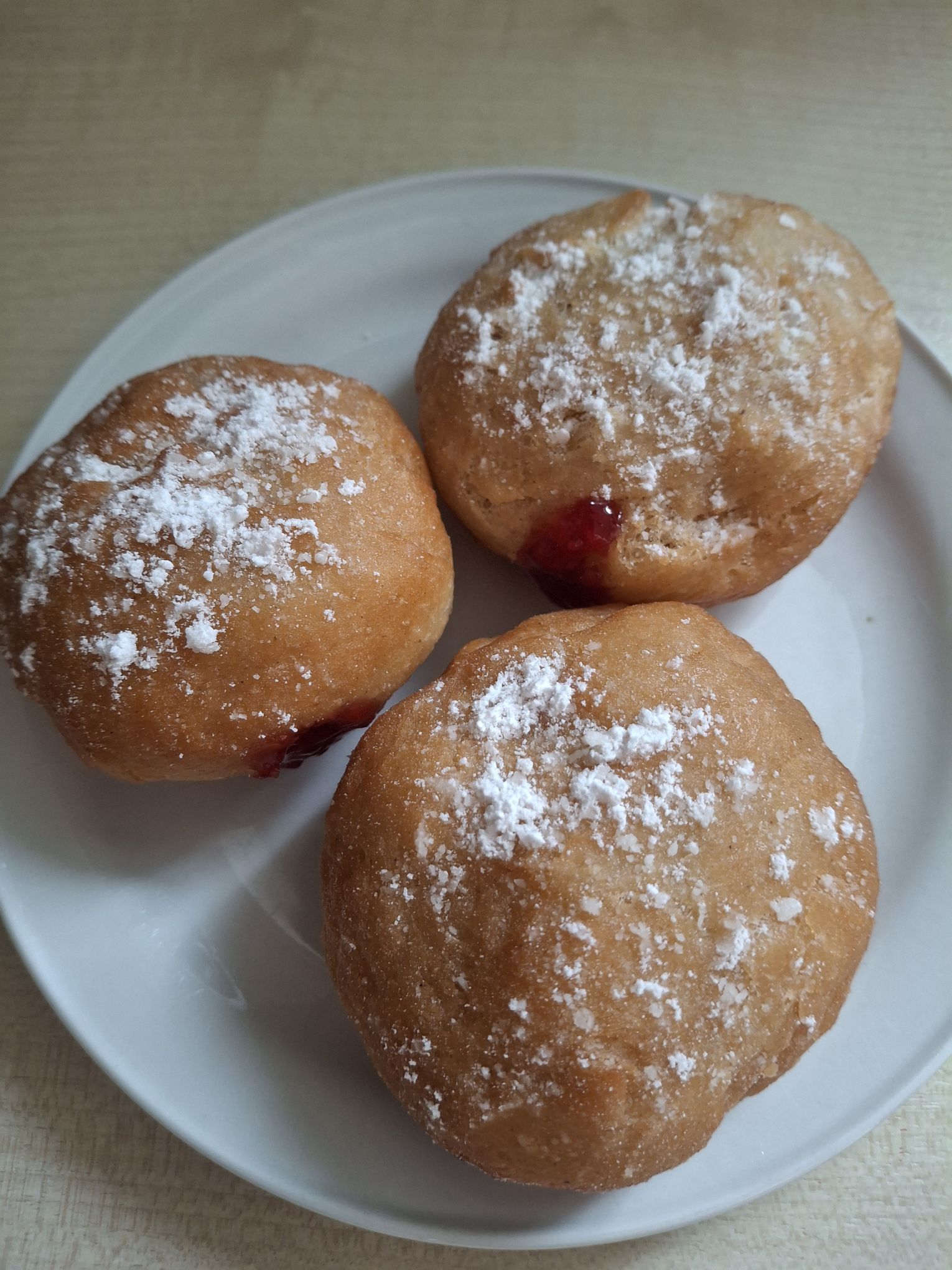 Berliner with raspberry jam and powdered sugar topping on a small plate from The Unofficial Animal Crossing Cookbook