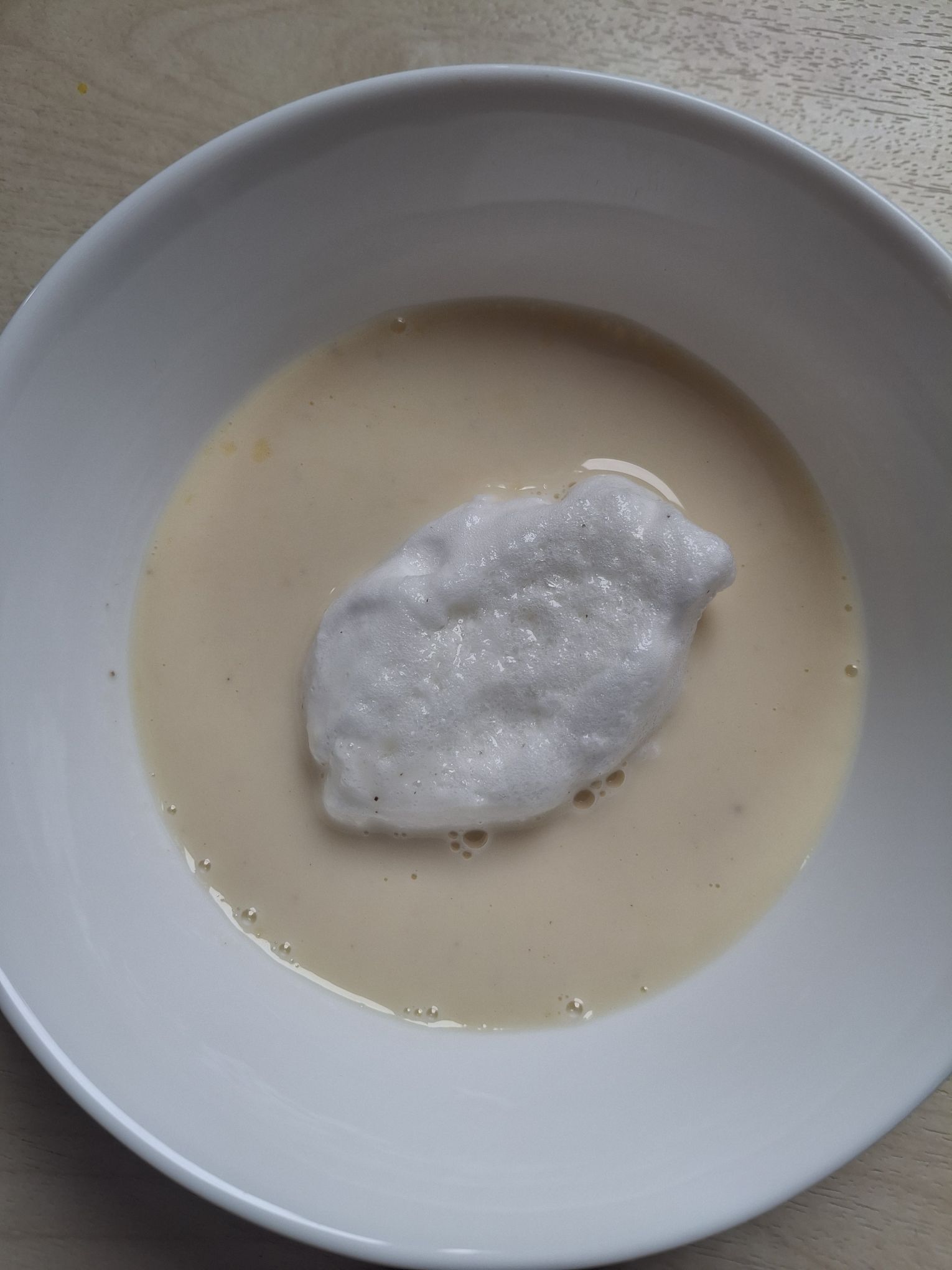 Îles Flottantes with a poached meringue floating in a bowl of crème anglaise from Emily in Paris: The Official Cookbook