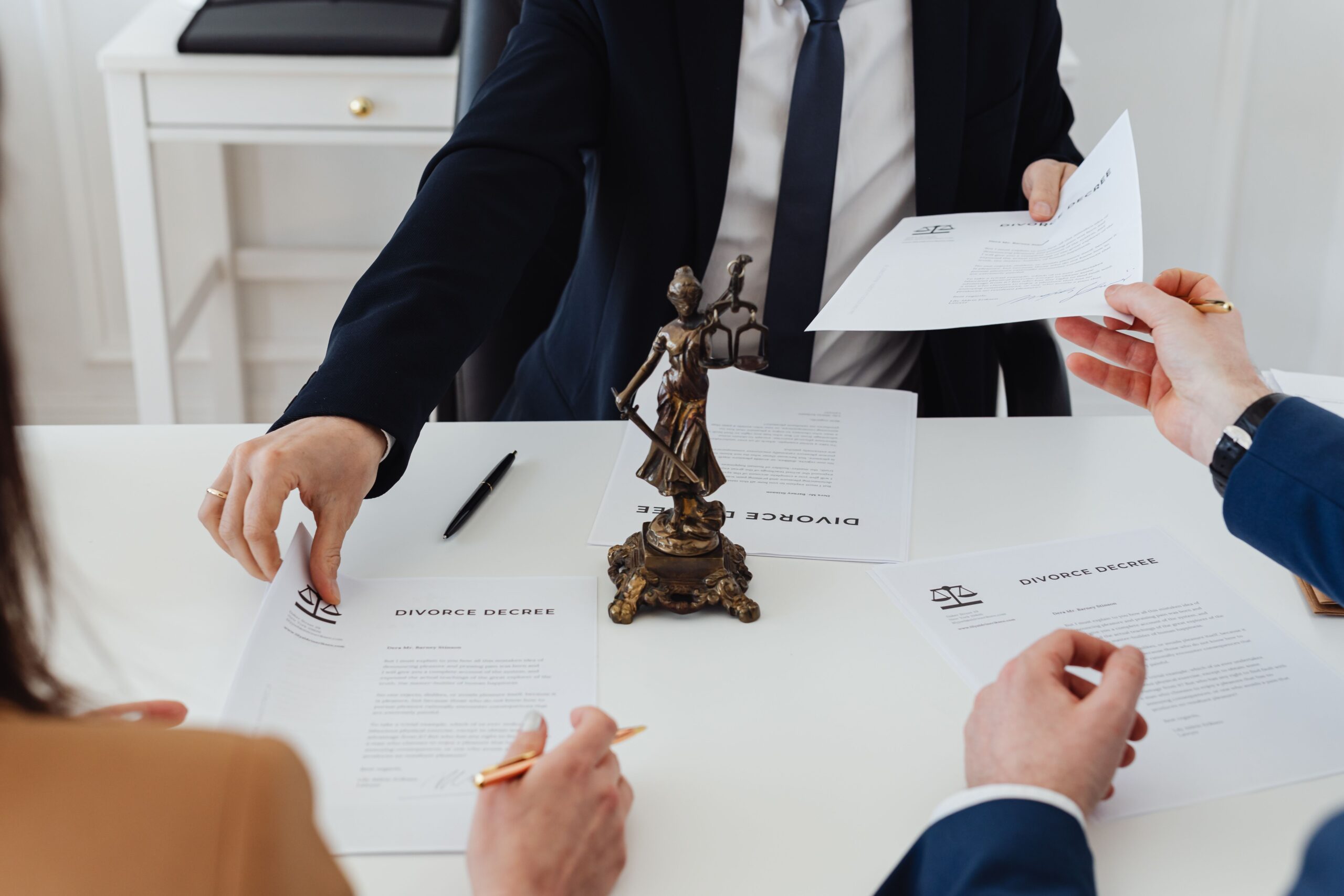 A couple sitting with an attorney and looking over a divorce decree