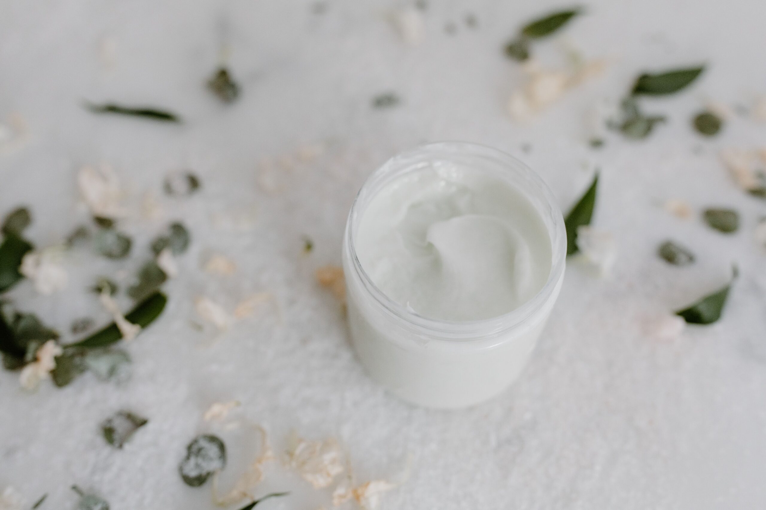 A close-up of an opened jar of white cream
